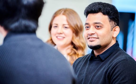 Three postgraduate business students sat having a discussion